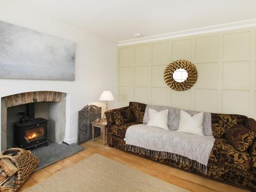 a living room with a couch and a fireplace at Tri Raglan Bach in Beaumaris