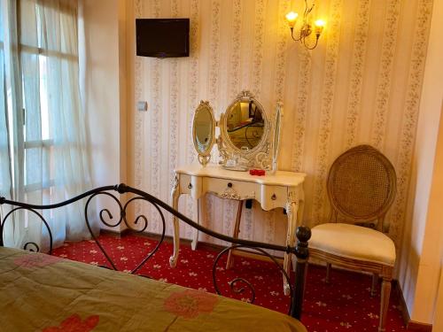 1 dormitorio con cama, espejo y silla en Hotel Mirto, en Litóchoron
