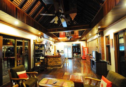 a living room with a ceiling fan and a table at Kong Garden View Resort Chiang Rai in Chiang Rai