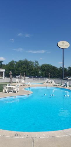 a large blue swimming pool with tables and chairs at Heritage Hotel Lancaster in Lancaster