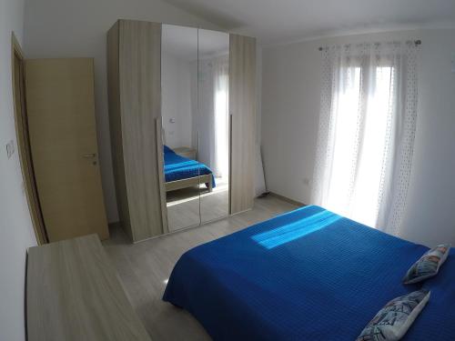 巴德西的住宿－Aquilone，一间卧室配有蓝色的床和镜子