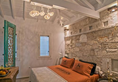 a bedroom with a bed and a stone wall at Eftopia Beachfront Studio in Kokkari