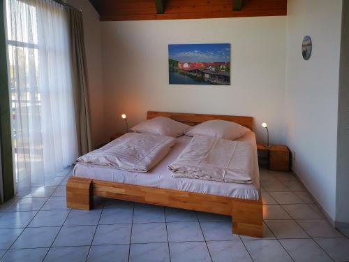 1 dormitorio con 1 cama de madera y 2 almohadas en 1-Zimmer-Ferienwohnung, en Plau am See