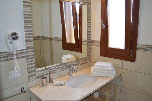 La salle de bains est pourvue d'un lavabo et d'un miroir. dans l'établissement Guest Rooms Affittacamere, à San Teodoro