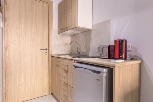 a small kitchen with a sink and a refrigerator at Paul Marie Hotel Apartments in Ayia Napa