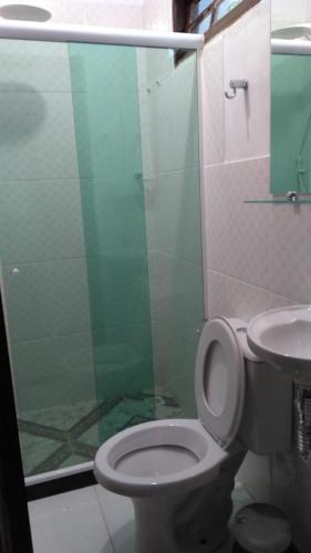 a bathroom with a toilet and a glass shower at Chales do Antonio in São Pedro da Serra