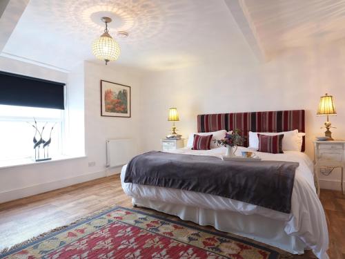 a bedroom with two beds and a large window at Vista Marina - Penthouse in Criccieth
