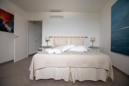 a bedroom with a bed with white sheets and pillows at Il Gabbiano Relais in Stromboli in Stromboli