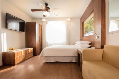 a bedroom with a bed and a ceiling fan at Krystal Grand Nuevo Vallarta in Nuevo Vallarta 