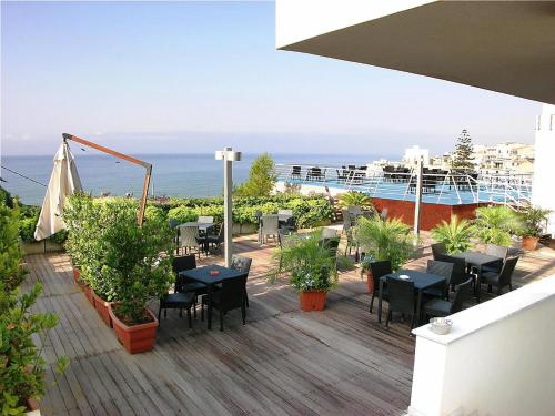 a deck with tables and chairs on a cruise ship at Hotel Admeto in Marinella di Selinunte