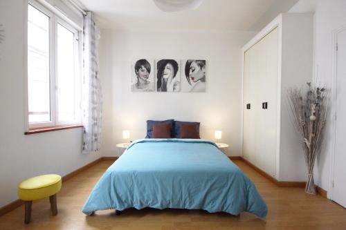 1 dormitorio con 1 cama azul y 1 silla amarilla en " Le Carla " Fécamp Bord de mer, en Fécamp