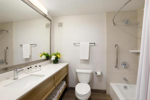 a bathroom with a toilet and a sink and a tub at The Wayfarer San Diego in San Diego
