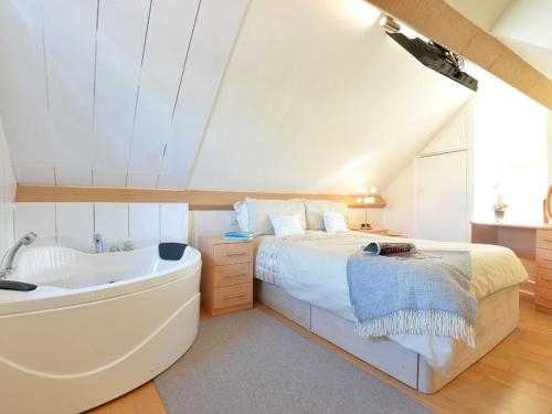 1 dormitorio con cama y bañera en Y Stabl, en Criccieth