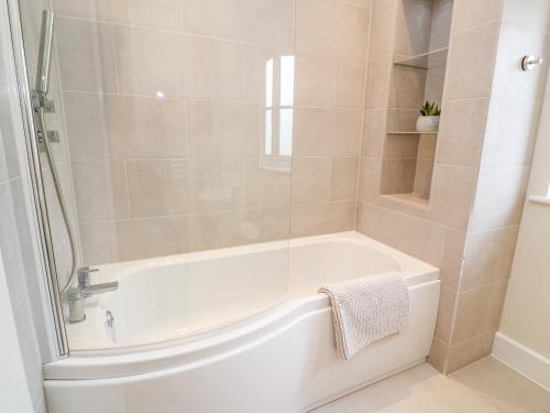 uma casa de banho com uma banheira branca e um chuveiro em Tinners Rest em Penzance