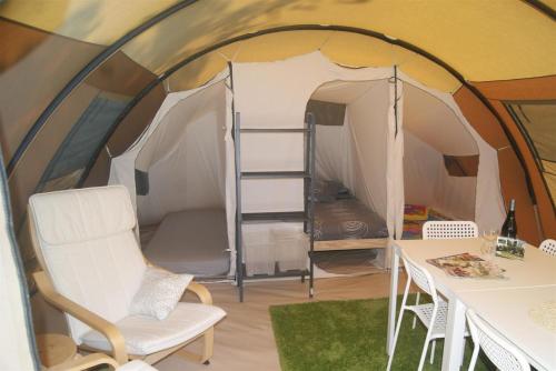 een tent met een tafel en stoelen ervoor bij Camping Les Arbois in Montjay