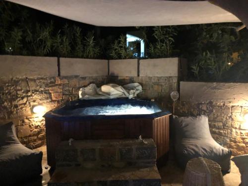 a hot tub in a room with a stone wall at Relux Suite in Agios Nikolaos