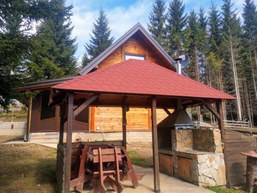 a small cabin with a red roof and a stove at Brvnare Krstigora in Zaovine