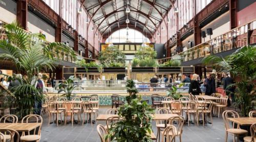 un grand bâtiment avec des tables et des chaises et une cafétéria dans l'établissement Vacances à Nice Terrasse ensoleillée & Parking à la Gare du Sud, à Nice