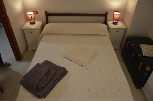 ein kleines Schlafzimmer mit einem Bett mit zwei Nachttischen in der Unterkunft Posizione_Strategica_SottoSopra_LaSpezia in La Spezia