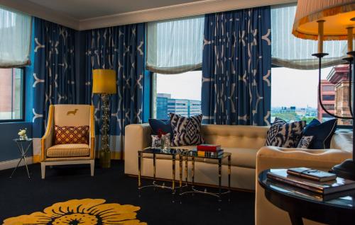 Kimpton Hotel Monaco Philadelphia, an IHG Hotel في فيلادلفيا: غرفة معيشة مع أريكة وكرسي