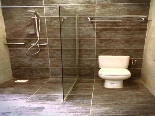 W łazience znajduje się toaleta i przeszklony prysznic. w obiekcie Senegambia Beach Hotel w mieście Sere Kunda NDing