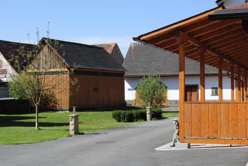 a house with a large wooden gate in a driveway at Gartler's Appartements in Kalsdorf bei Graz