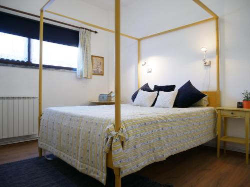 ナザレにあるCasa Terraçoのベッドルーム1室(四柱式天蓋付きベッド1台付)