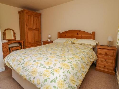 een slaapkamer met een groot bed en een houten hoofdeinde bij The Cottage at Manor Farm in York