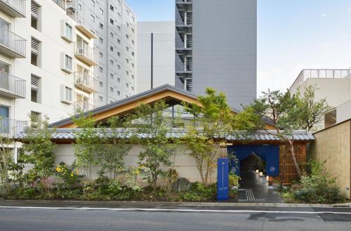 a building with a blue door in a city at ONSEN RYOKAN YUEN SHINJUKU in Tokyo