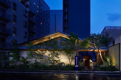a building in the middle of a city at night at ONSEN RYOKAN YUEN SHINJUKU in Tokyo