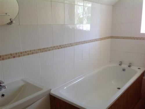 a white bathroom with a tub and a sink at The New Inn in Oswestry