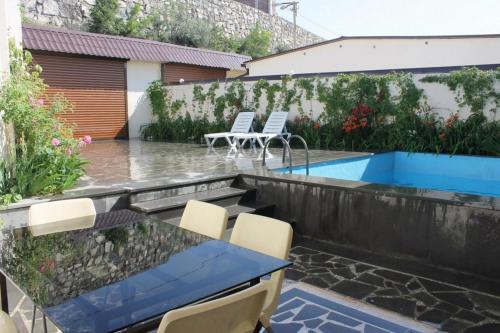 a patio with a table and chairs and a swimming pool at Large 5 bedroom VIP Villa 2 in Yerevan