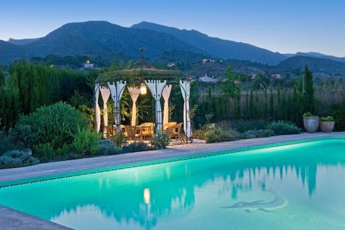 a swimming pool with a gazebo next to a mountain at La Venteta in Aigues