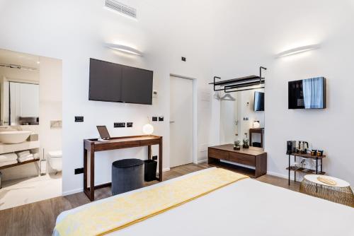 a bedroom with a bed and a desk and a tv at La Spezia by The First - Luxury Rooms & Suites in La Spezia
