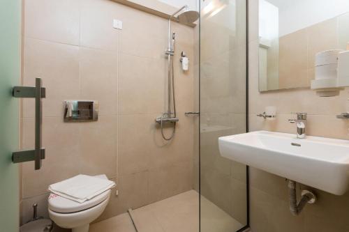 a bathroom with a shower and a toilet and a sink at Princess Golden Beach Hotel in Chrysi Ammoudia