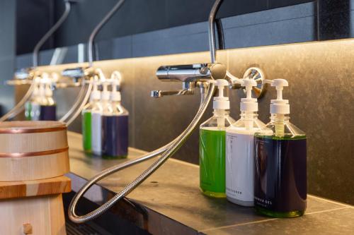 a group of four bottles sitting on top of a counter at ONSEN RYOKAN YUEN SHINJUKU in Tokyo