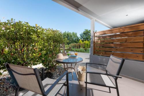 a patio with a table and chairs on a patio at Princess Golden Beach Hotel in Chrysi Ammoudia