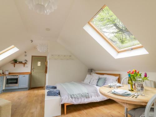 um quarto com uma cama, uma mesa e uma janela em Orchard Loft em Ivybridge