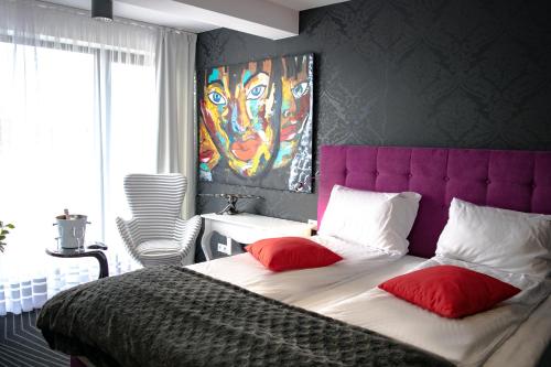 um quarto com uma cama grande e uma cabeceira de cama roxa em Axel Boutique Jacuzzi & Sauna em Dziwnów
