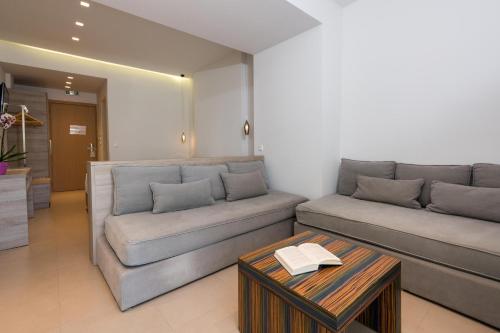 a living room with two couches and a table at Princess Golden Beach Hotel in Chrysi Ammoudia