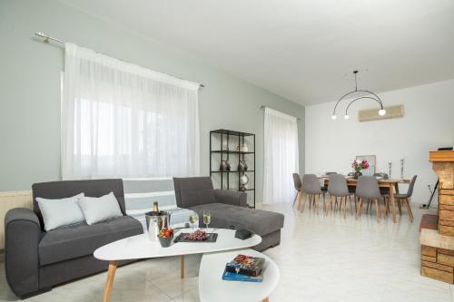 a living room with a couch and a table at M & S Villa - 3 bedroom villa with heated pool in Pastida