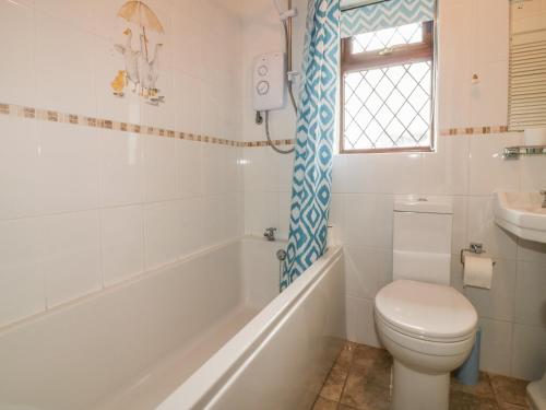 a bathroom with a toilet and a tub and a sink at Chiffchaff in Padstow