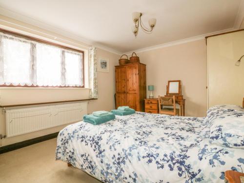 a bedroom with a bed and a window at Chiffchaff in Padstow