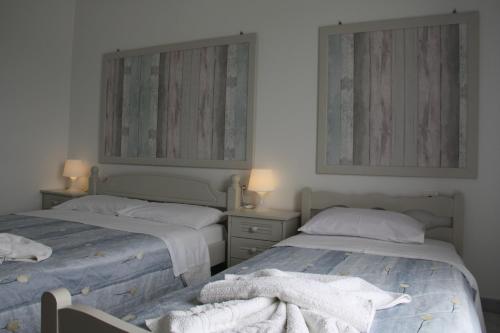 a bedroom with two beds with towels on them at Kalypso Apartments in Lipsoi