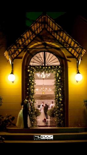 a bride and groom kissing under an arch with flowers at Villa Verde Hotel in Avaré