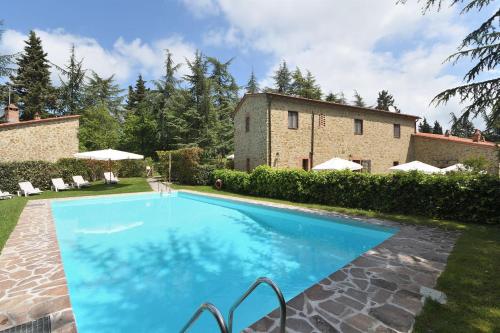 una gran piscina azul frente a una casa en Castellare in Chianti, en Gaiole in Chianti