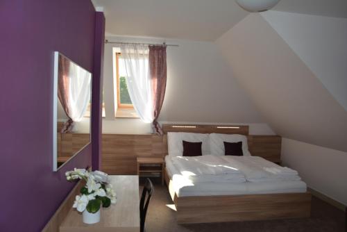 1 dormitorio con cama, ventana y mesa en Nobless Resort en Rožmitál pod Třemšínem