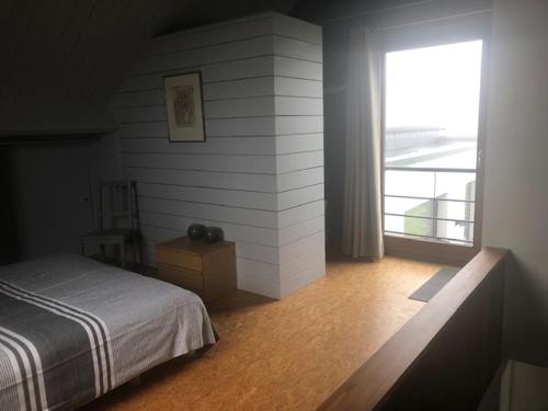 a bedroom with a bed and a large window at La Cassine de Patou in Stoumont
