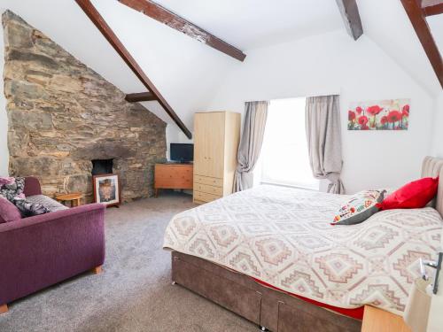 a bedroom with a bed and a stone fireplace at Tram View in Llandudno
