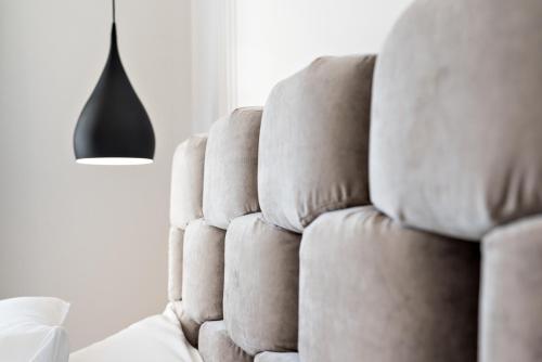 a white couch sitting in a living room next to a lamp at La Spezia by The First - Luxury Rooms & Suites in La Spezia